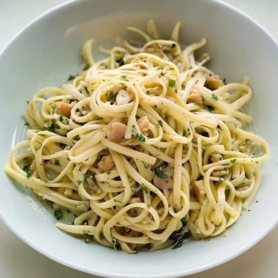 Guido's linguine with clams, garlic, and parsley in a white bowl.