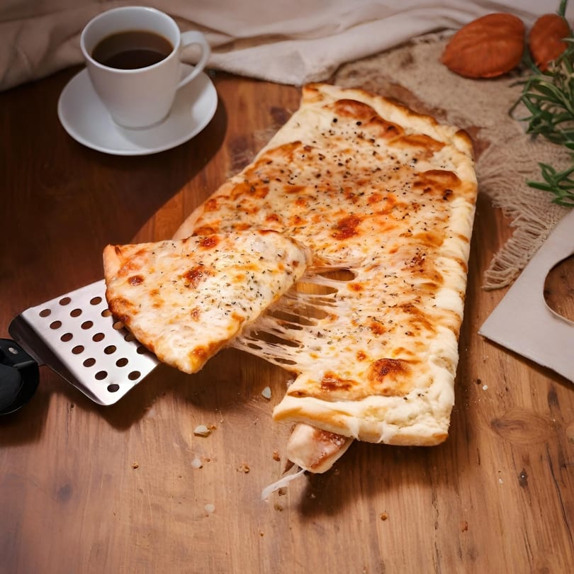 A cheesy slice of Guido's Pizza & Pasta's focaccia bread being lifted, stretching melted cheese.